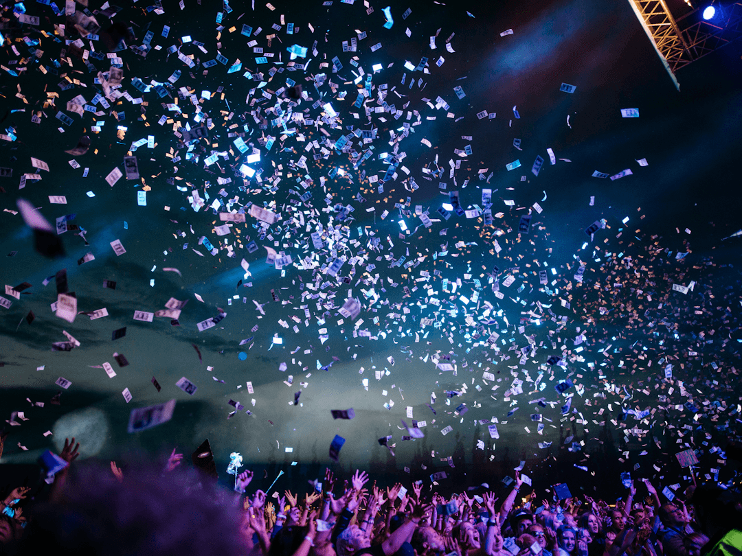 A full house celebrating under falling confetti